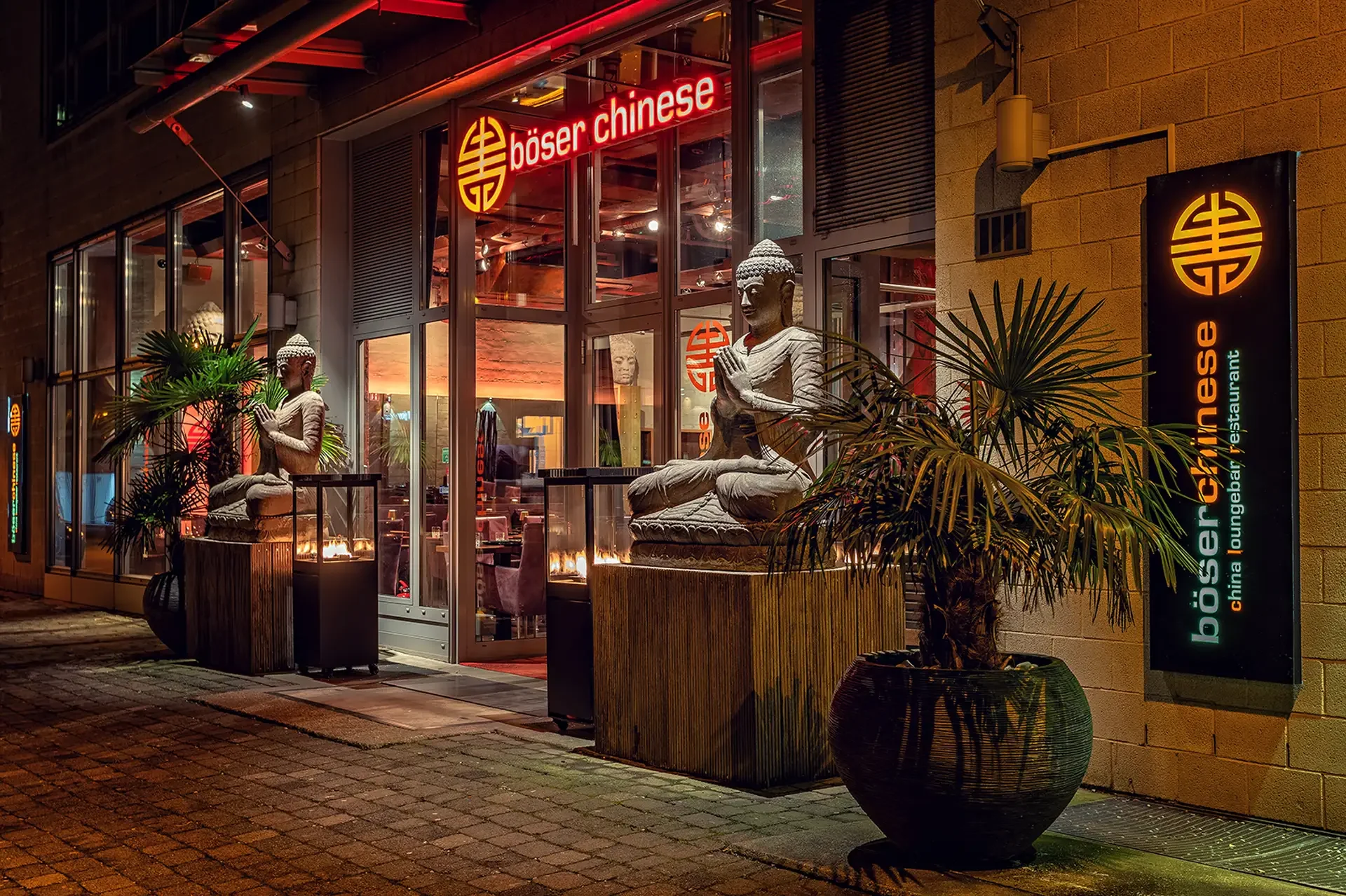 Beleuchteter Eingang eines asiatischen Restaurants im Düsseldorfer Medienhafen am Abend